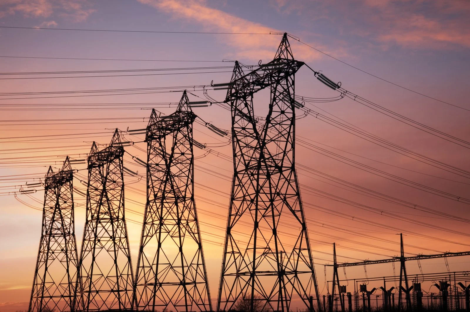 high voltage pylons silhouette cloudy sky background